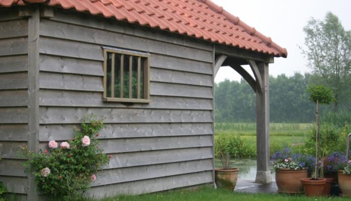 eiken bijgebouw met houten poolhouse en potdekselgevel bij natuur zwemvijver