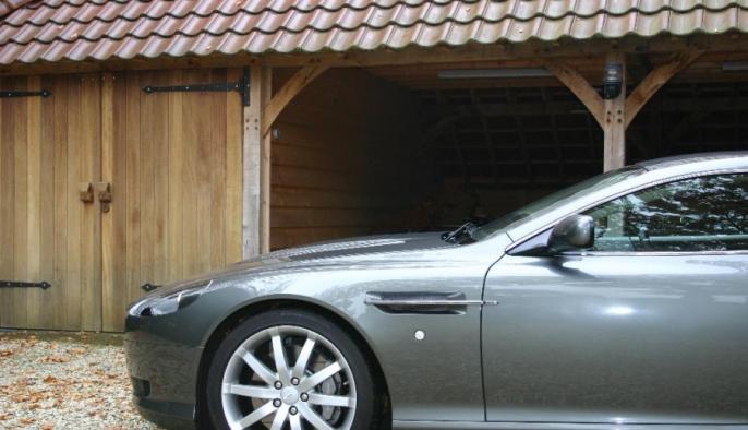 eiken bijgebouw met carport en houten garage voor aston martin