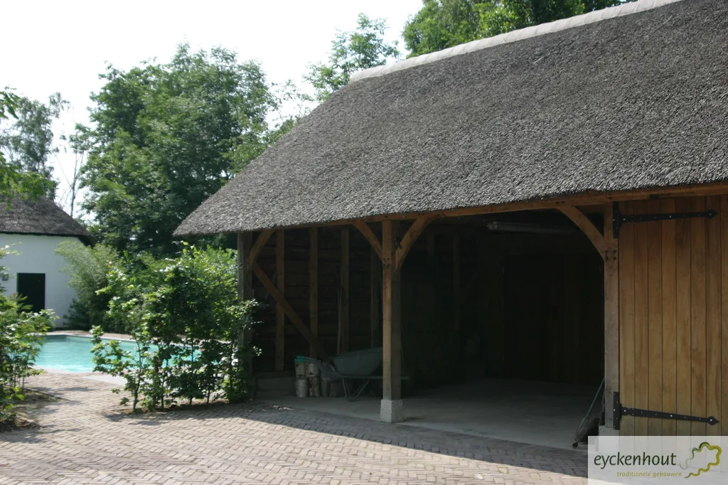 Eiken carport met rieten kap bij een zwembad