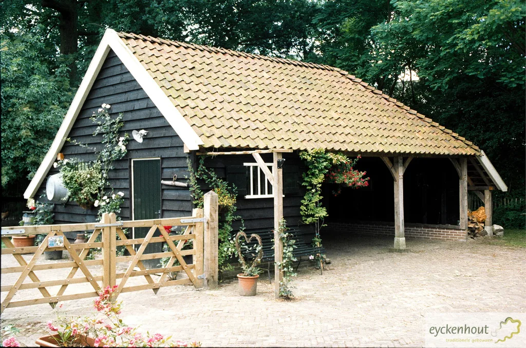 Garage met zwarte gevel en oude pannen