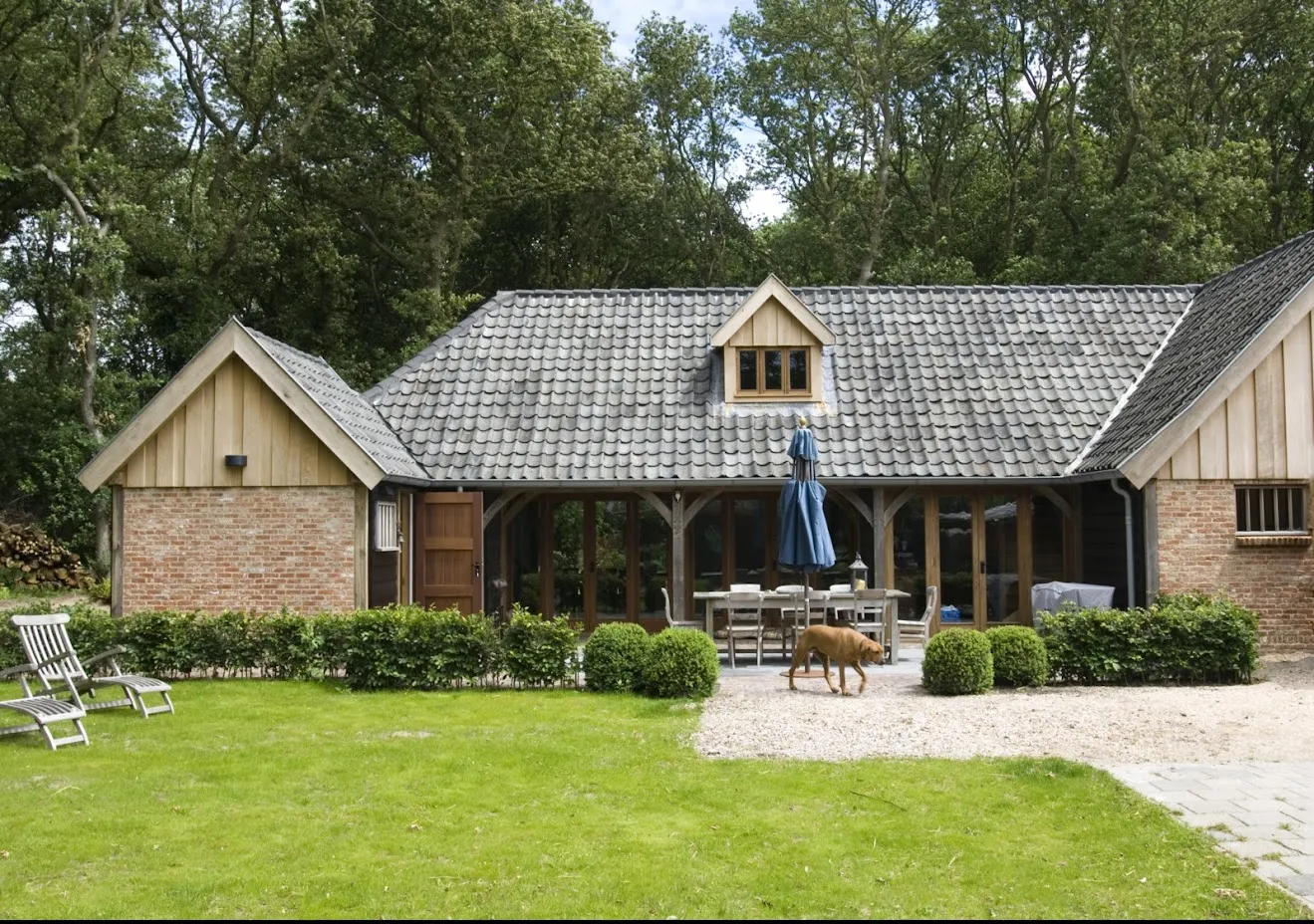 Gastenverblijf met oude holle dakpannen en een overdekt terras