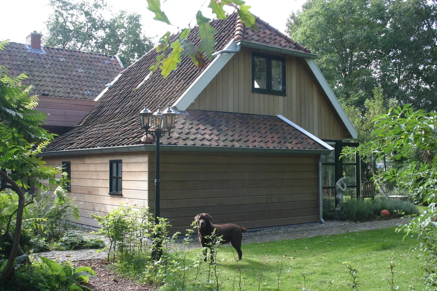 De uitbreiding met dakkapel, met een pony in de tuin