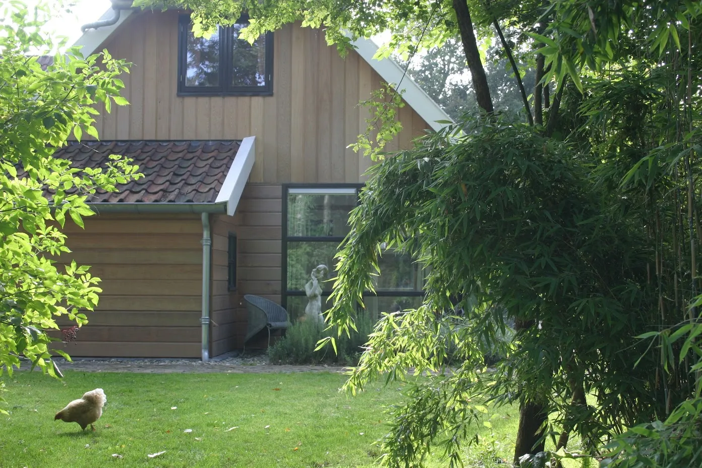 De uitbreiding met eiken gevelbekleding, gezien vanuit de tuin