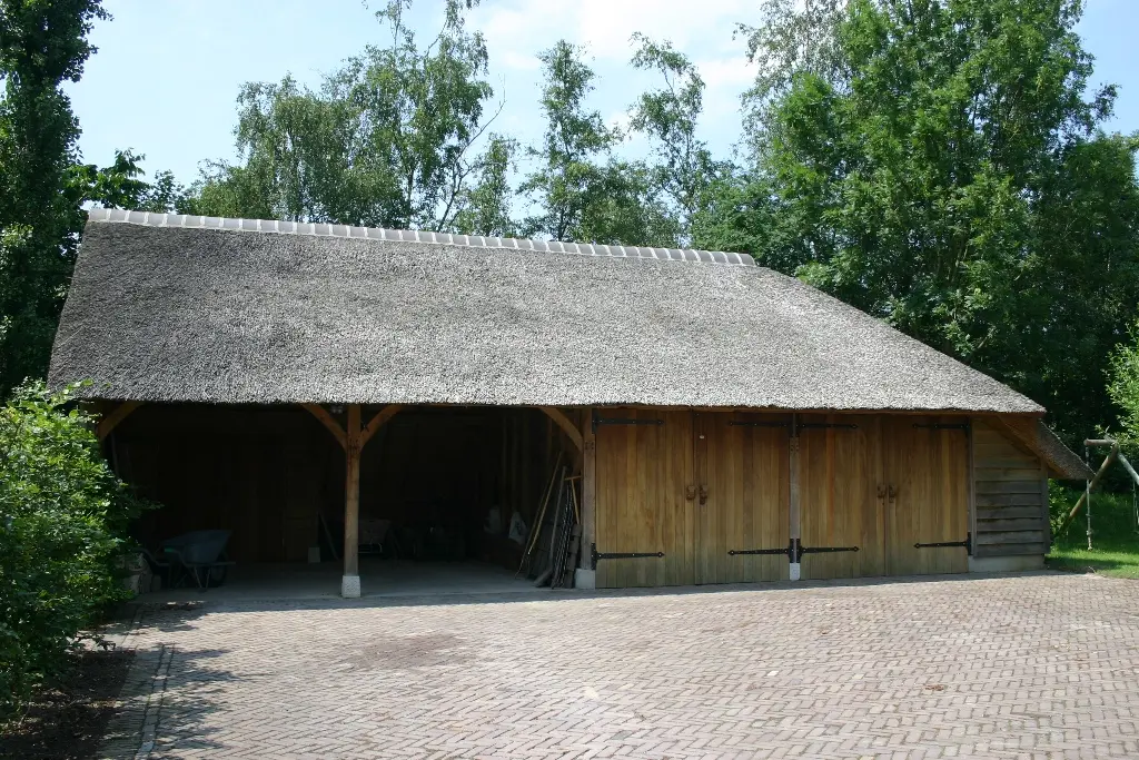 Eiken bijgebouw met carport en rieten dak