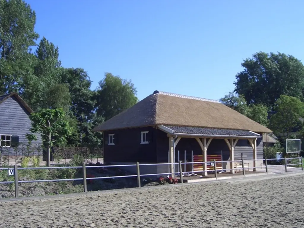 Eiken bijgebouw met rieten kap bij stal