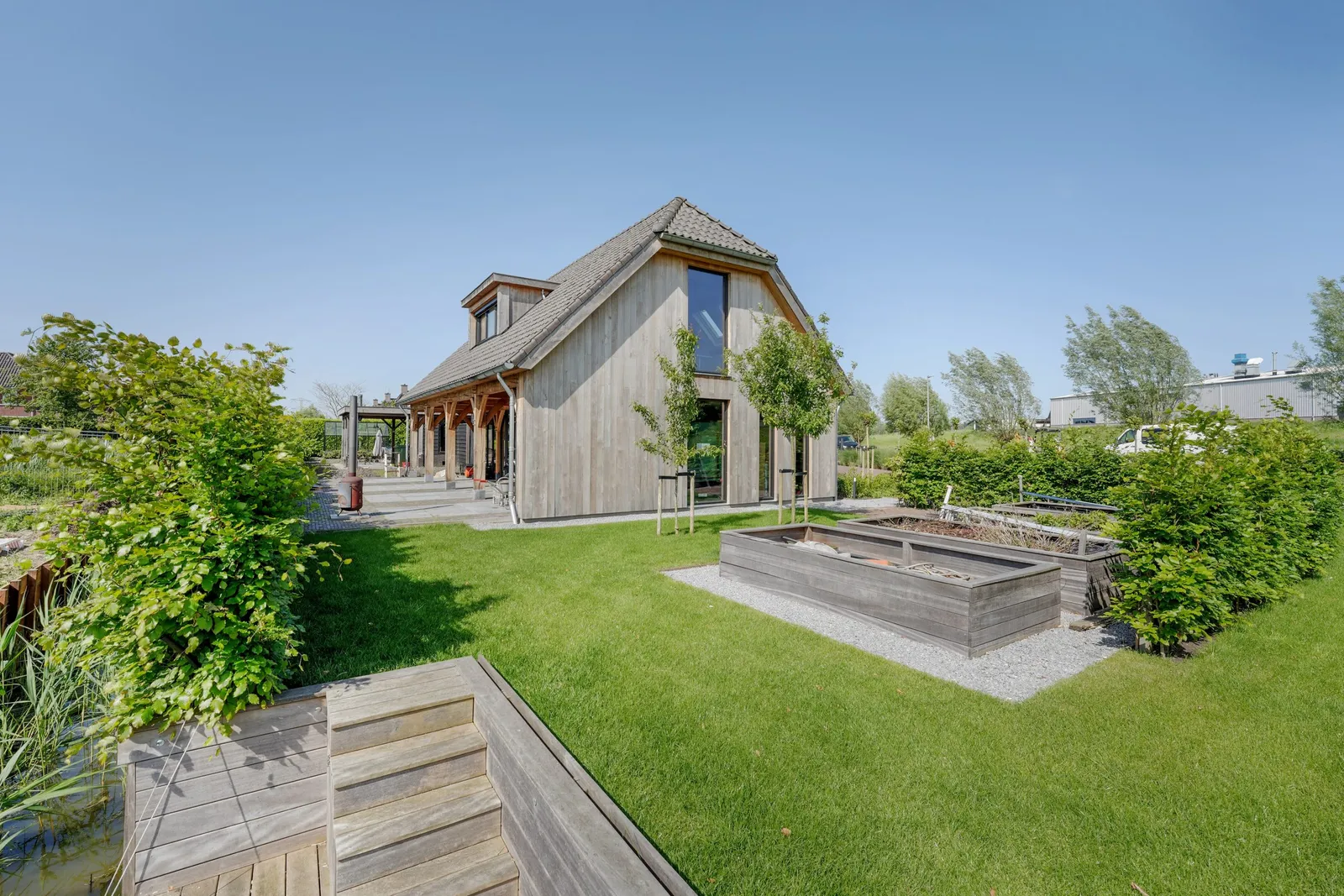 Eiken veranda aan de woning, met de tuin op de voorgrond