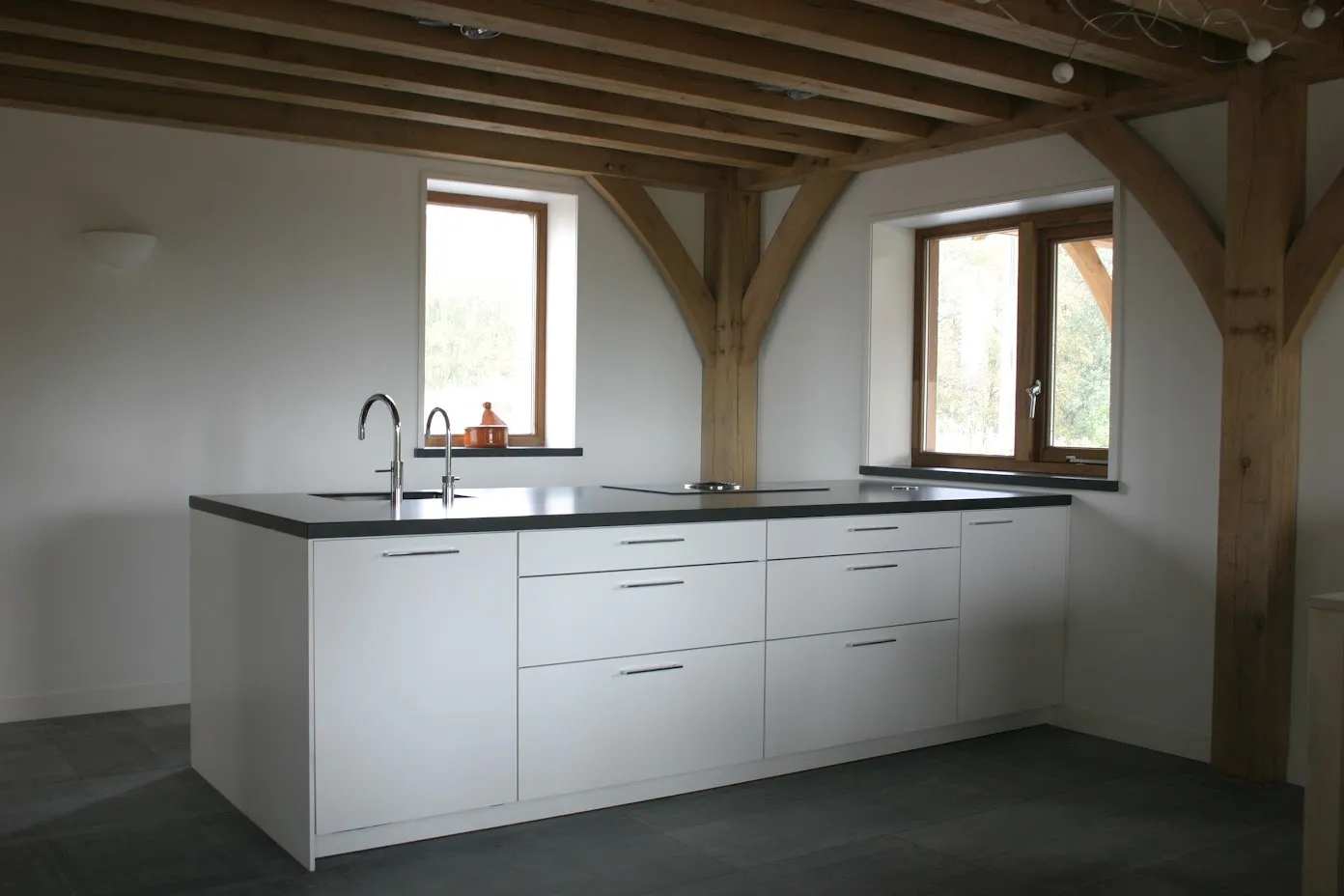 Witte keuken onder het eiken balkenplafond