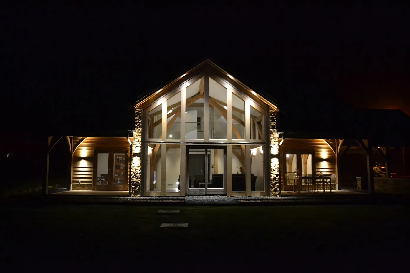 De woning bij avond, met de glazen topgevel verlicht